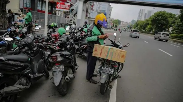 Pegemudi ojol mengantar barang dari pusat perbelanjaan. 