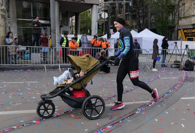 Devojka trči maraton i gura kolica sa bebom