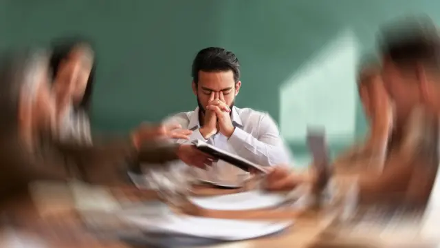 Stres, migrena i rozmycie obrazu u pracownika, który czuje się sfrustrowany, zmęczony lub przepracowany na spotkaniu. 