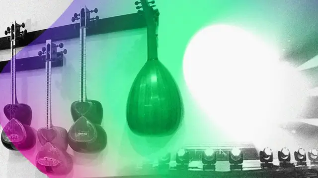 تصویر چند تار و یک تنبور که آویزان شده‌اند در پس‌زمینه رنگی