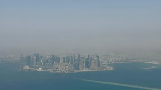 نمای شهر دوحه از پنجره هواپیما. آسمان شهر غبارآلود است