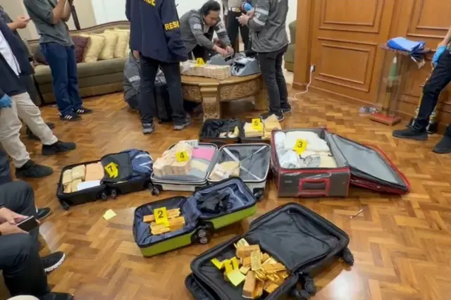 Polisi sedang menghitung jumlah emas batangan dan uang tunai dari dalam kawasan Sentul, Kecamatan Babakan Madang, Kabupaten Bogor.
