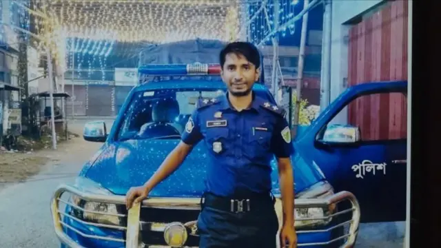 বানিয়াচং থানায় নিহত এস আই সন্তোষ চৌধুরী পুলিশের গাড়ির সাথে হেলান দিয়ে দাঁড়িয়ে আছেন।