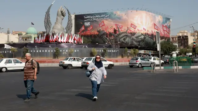 أشخاص يمرون أمام لوحة مناهضة للولايات المتحدة في طهران