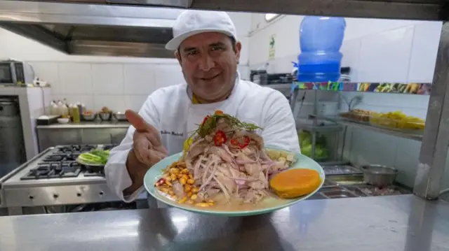 Un cocinero muestra un plato de cebiche. 