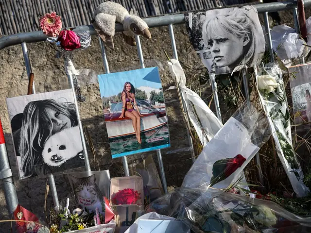 Ограждение, к которому прикреплены фотографии Бардо и цветы. На фотографии можно также увидеть фото кота и мягкую игрушку в виде животного.