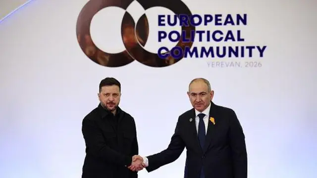 Володимир Зеленський, Нікол Пашинян тиснуть руки на фоні банера Європейського політичного співтовариства. 