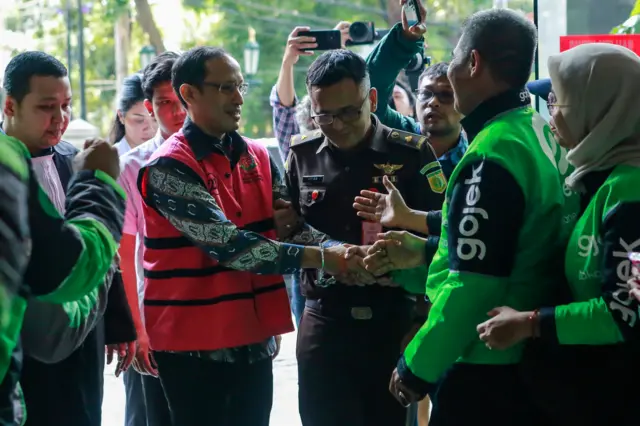Terdakwa kasus dugaan korupsi pengadaan Chromebook dalam program digitalisasi pendidikan di Kemendikbudristek Nadiem Makarim (kedua kiri) menyapa pengemudi Gojek saat mengikuti sidang lanjutan di Pengadilan Tipikor, Jakarta, Senin (11/05)