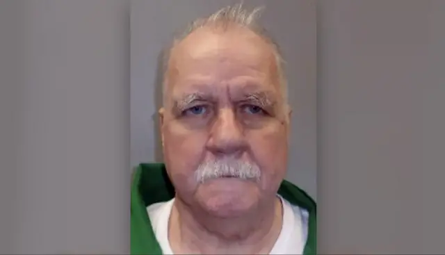Foto de Brad Sigmon, um homem branco idoso de bigode e cabelos brancos ficando ralos 