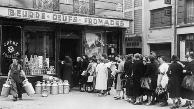 Des femmes françaises font patiemment la queue devant un supermarché pour acheter de la nourriture.