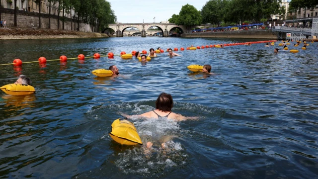 Pessoas nadam no rio Sena no local de Bras Marie, aberto para banhistas, marcando a primeira sessão de banho público no histórico canal da capital, em Paris