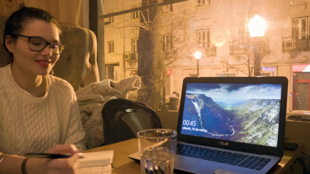 Jovem trabalha ao lado de notebook