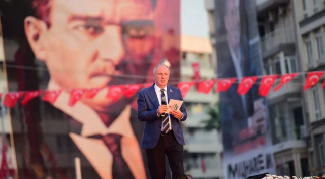 Muharrem İnce 2018'deki cumhurbaşkanlığı seçiminde İzmir'de miting yapıyor, sahnede tek başına ve arkada büyük bir Atatürk fotoğrafı var.