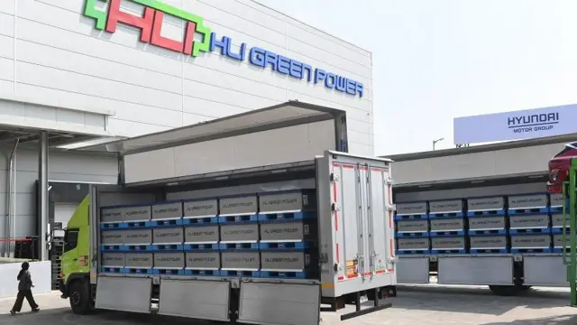 Pekerja berjalan di dekat kontainer yang mengangkut sel baterai di pabrik baterai kendaraan listrik PT Hyundai LG Industry (HLI) Green Power usai diresmikan di Karawang, Jawa Barat, Rabu (3/7/2024). Pabrik sel baterai kendaraan listrik terbesar di Asia Tenggara itu dibangun oleh konsorsium perusahaan asal Korea Selatan Hyundai dan LG dengan total investasi senilai Rp160 triliun yang akan diselesaikan secara bertahap.