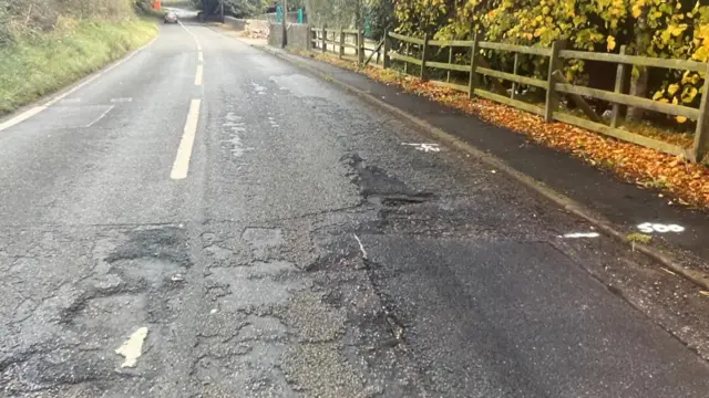 Baches en un camino largo. Hay una valla a la derecha.