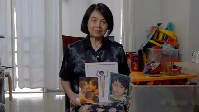 Angelia Susanto memegang foto anaknya Enrico Johannes Susanto Carluen yang tak diketahui keberadaaannya sejak tahun 2020. 