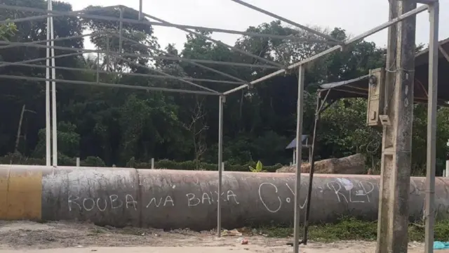 'Rouba na baixa C.V' escrito em cano, perto de mata