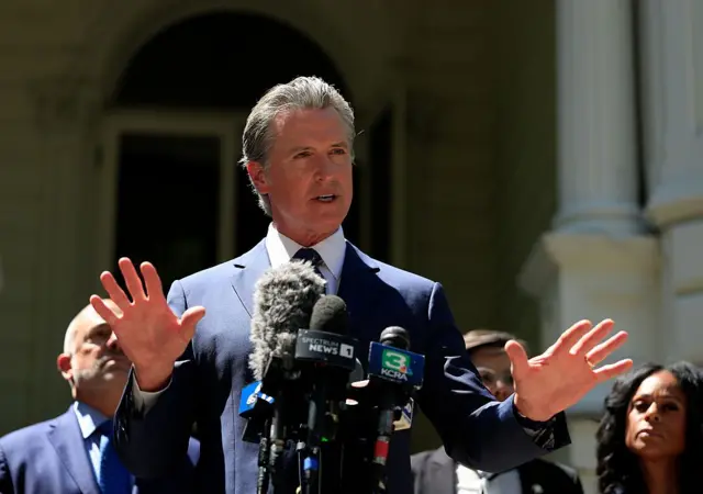 El gobernador de California, Gavin Newsom, habla con las manos abiertas y las palmas hacia abajo en una conferencia de prensa en apoyo de los demócratas de Texas. 