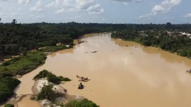 Overhead view of one of Ghana rivers wey now don turn dark brown due to heavy pollution by illegal mining activities