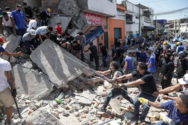 Rescatistas y vecinos trabajan en las ruinas de un edificio derrumbado en Cali.