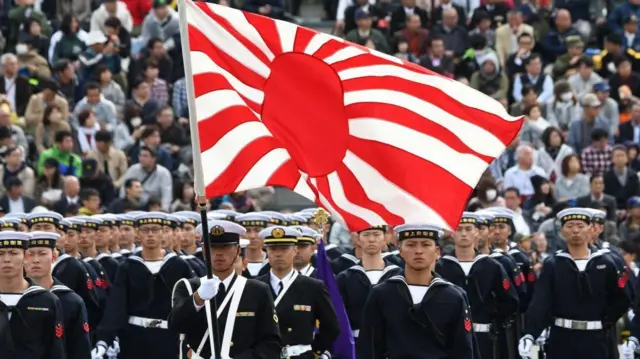 日本海上自衛隊旗幟於2018年10月14日在埼玉縣朝霞市的陸上自衛隊朝霞訓練場舉行的閱兵檢閱中可見。約4,000名人員、260輛車輛和40架飛機參加了這次軍事閱兵。