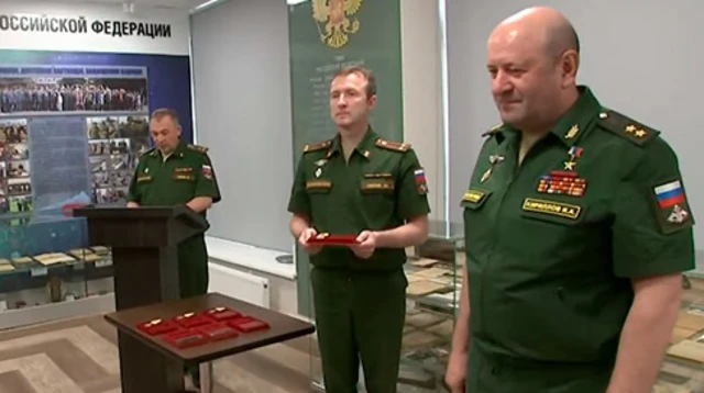 Igor Kirillov, à droite, vêtu d'un uniforme militaire russe vert, remet des médailles à d'autres soldats de l'armée russe