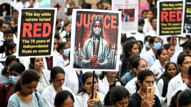 Para profesional medis memegang poster di sebuah rumah sakit di Bengaluru pada 17 Agustus 17, di tengah pemogokan nasional yang dilakukan para dokter untuk mengutuk pemerkosaan dan pembunuhan petugas medis muda dari Kolkata