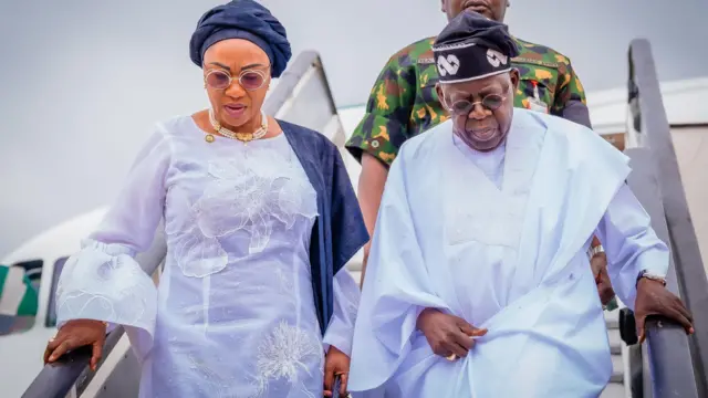 Aarẹ Bola Tinubu ati iyawo rẹ Oluremi Tinubu n sọkalẹ lati inu ọkọ ofurufu pẹlu aṣọ funfun lọrun wọn