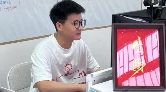 Feiyu isimli şirket sahibi Çinli bir ekranın önünde oturuyor.