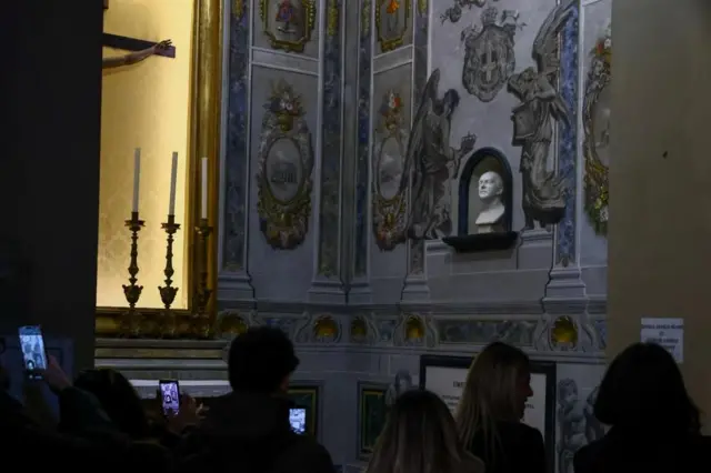 Varias personas toman fotos de la restauración.