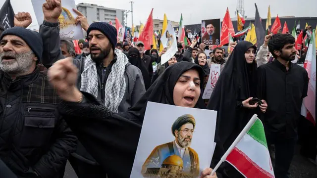 ईरान के नए सर्वोच्च नेता अयातुल्लाह मोजतबा ख़ामेनेई की तस्वीर लिए हुए सरकार के समर्थकों ने 13 मार्च, 2026 को तेहरान में अंतर्राष्ट्रीय कुद्स दिवस के मौके पर आयोजित एक रैली के दौरान अमेरिका और इसराइल विरोधी नारे लगाए.
