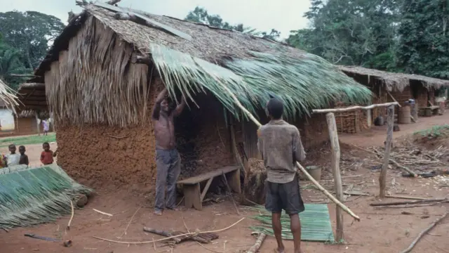 Ụmụnwoke abụọ na-atinye akịrịka n'elu ụlọ aja.