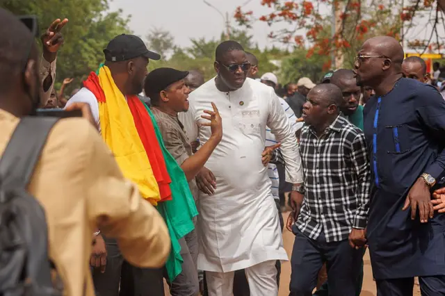 Cheick Oumar Diarra (C), leader de la jeunesse pro-démocratique, est accueilli par des sympathisants lors d'une manifestation organisée par une large coalition de partis politiques craignant une dissolution par les autorités militaires du Mali, à Bamako, le 3 mai 2025.