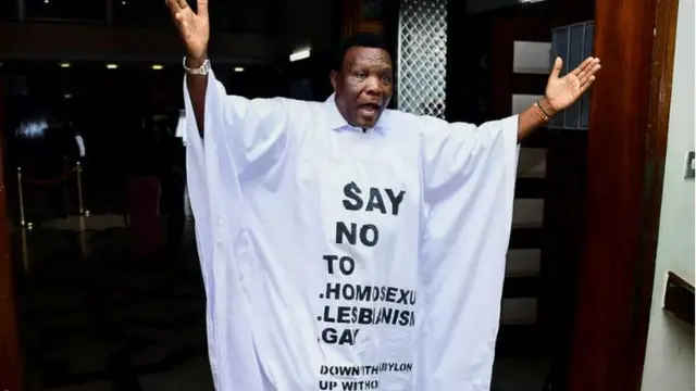 Anggota parlemen Uganda John Musira mengenakan gaun dengan slogan anti-homoseksual untuk rapat di parlemen