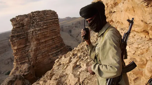 Um guerrilheiro da tribo Marri do povo Baloch conversa com um postoobservação rebelde enquanto monitora os movimentos das tropas paquistanesas na província do Baluchistão