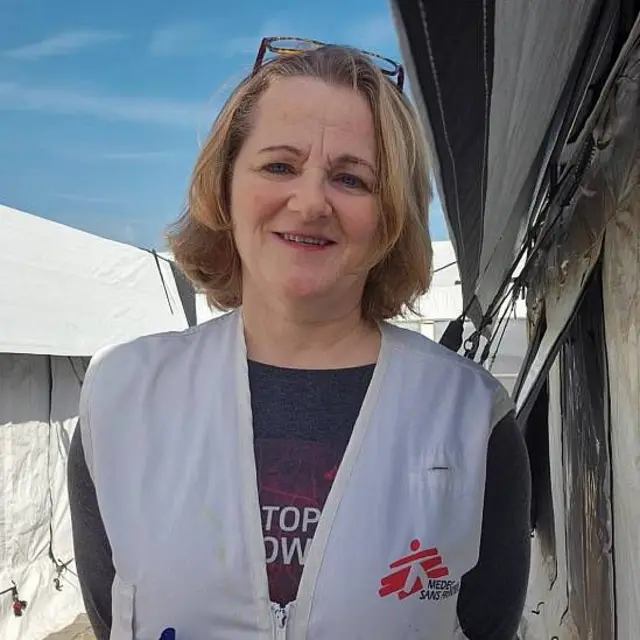 Katrin Glatz Brubakk sonríe a la cámara en un campamento de tiendas de campaña en Gaza. LLeva un chaleco con la insignia de Médicos Sin Fronteras