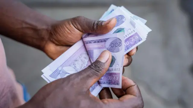 የሁለት መቶ ብር ኖቶችን የሚቆጥር ወንድ እጅ
