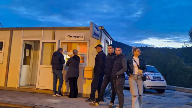 Ljudi stoje ispred barake u kojoj je Pošta