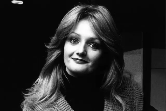 Imagem em preto e branco de uma jovem Bonnie Tyler, com longos cabelos que caem além dos ombros. Ela veste um suéter de lã com estampa xadrez em V e uma camiseta de manga comprida por baixo.