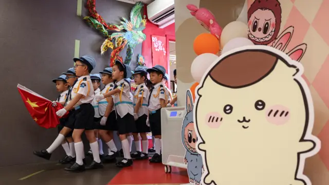 گروهی از دانش‌آموزان مهدکودکی در چین پرچم این کشور را در دست دارند و به صف شده‌اند