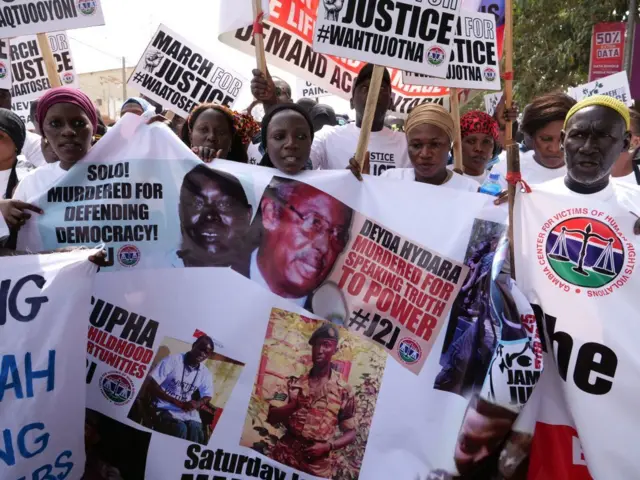 Des manifestants tiennent des banderoles portant les visages de victimes du régime de Yahya Jammeh, l'ancien président de la Gambie, lors d'un rassemblement à Banjul, le 25 janvier 2020 pur demander la traduction en justice de l'ancien président.