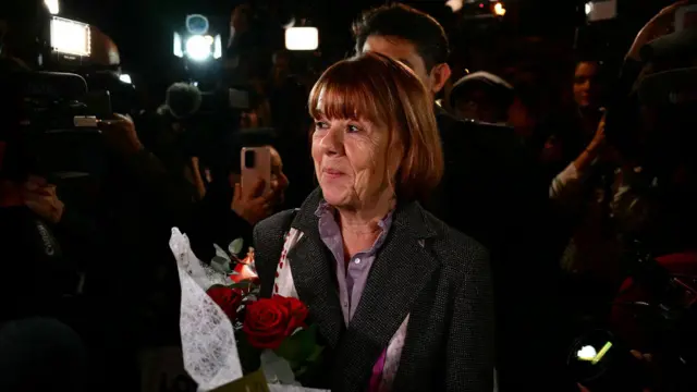 Пані Пеліко з квітами на виході з будівлі суду в Авіньйоні