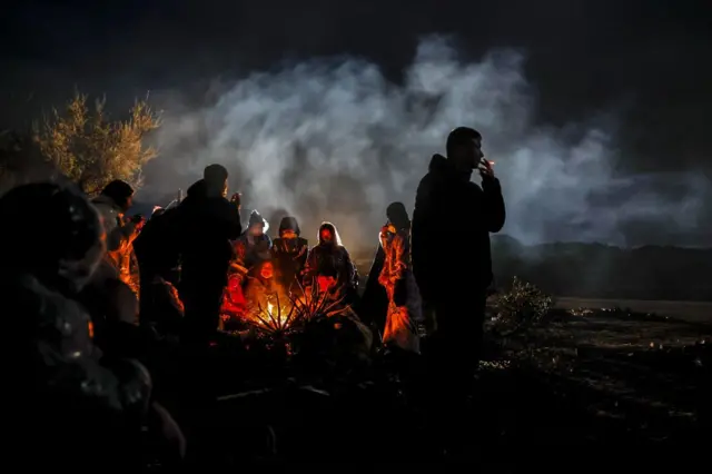 Migrantes ao lado de fogueira em Jacumba, na Califórnia