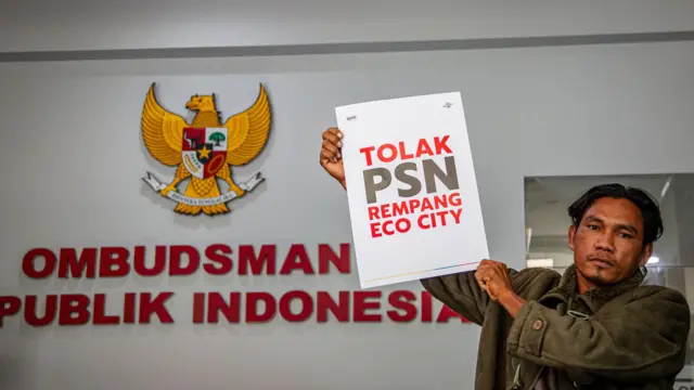 Seorang warga Pulau Rempang memegang poster usai melakukan audiensi di gedung Ombudsman, Jakarta, Selasa, 13 Agustus 2024.