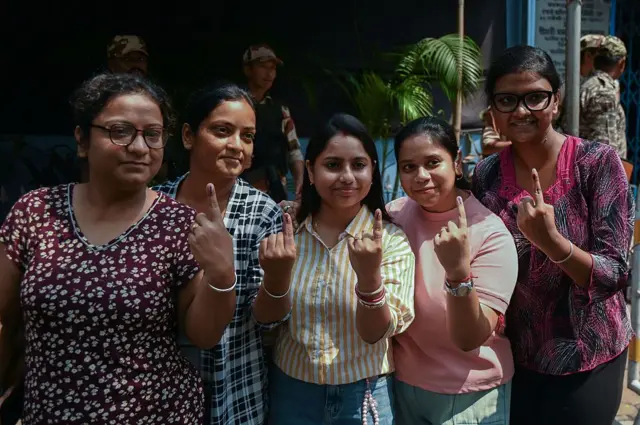 Sekelompok perempuan memamerkan tinta pada jari setelah mengikuti pemilihan umum legislatif di Kolkata, India.