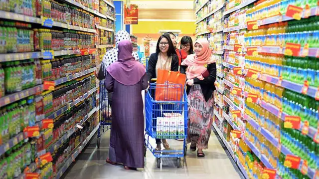 Pelanggan mendorong kereta belanja di salah satu di Karawaci, Banten.