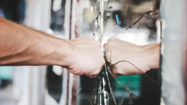 একটি পুরুষের হাতের আঘাতে আয়না ফেটে গেছে