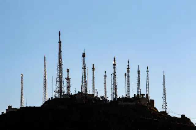 Widok na wieże telefonii komórkowej zainstalowane na wzgórzu w Kabulu w Afganistanie.