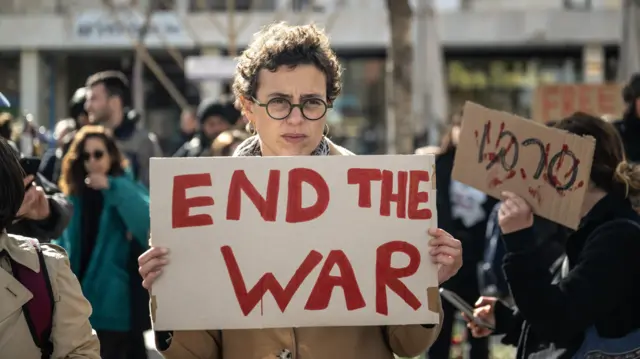 متظاهرون يحملون لافتات أثناء تجمعهم في القدس الغربية للمطالبة بوقف إطلاق النار في غزة وإطلاق سراح الرهائن