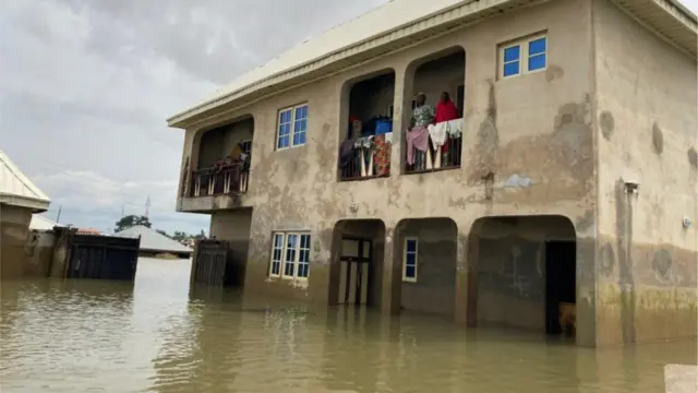 Mutane tsaye a hawa na sama na gidan  Mohammed Sani Gambo